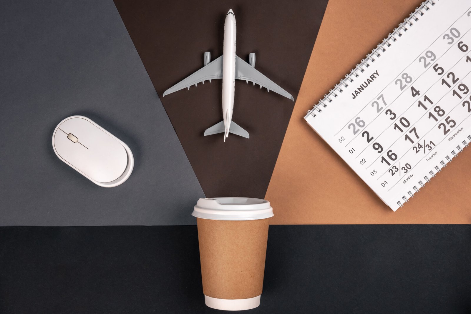paper cup, computer mouse, calendar and airplane model, top view.